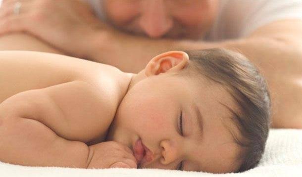 A dad watching his young son sleep